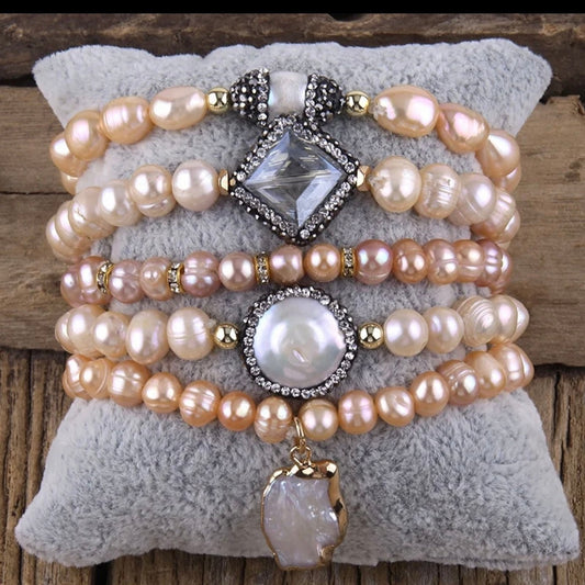 Stack of pearl bracelets with decorative elements on a textured surface