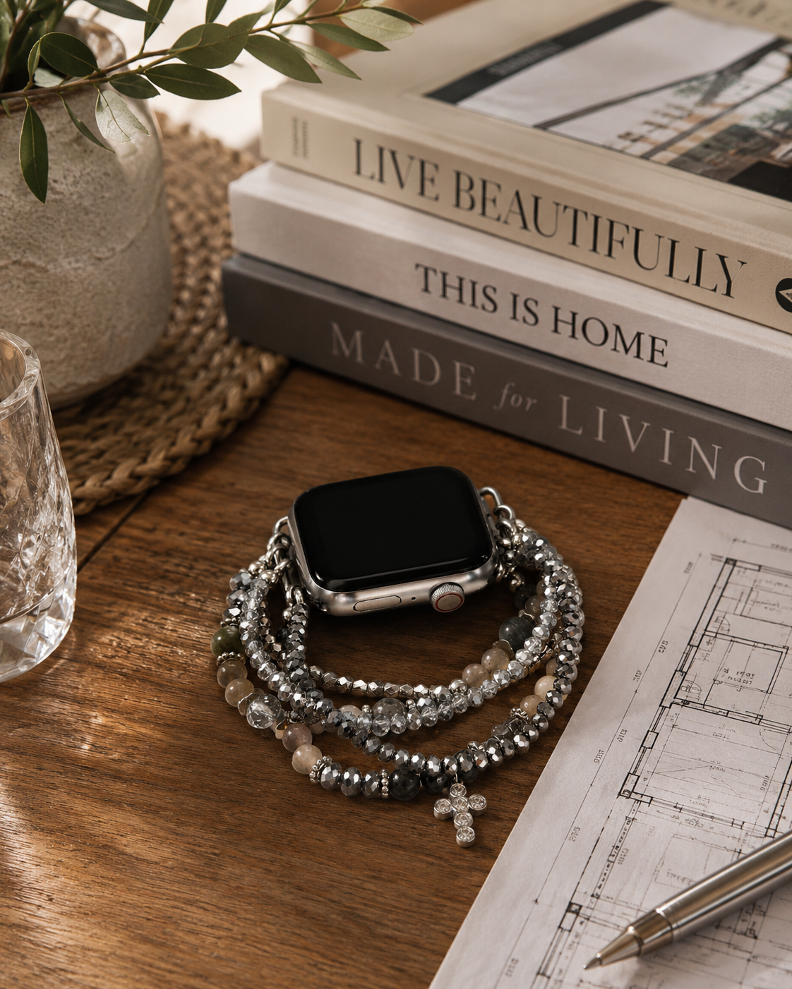 Stack of books with a decorative bracelet on a wooden surface