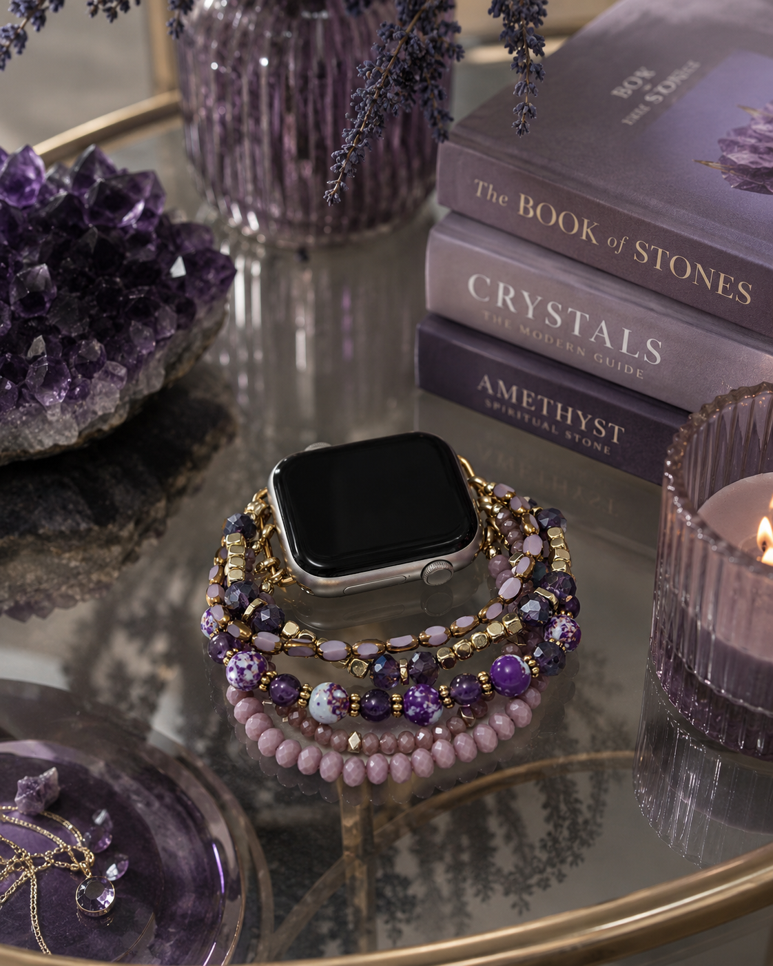 Smartwatch with purple beaded band on a reflective surface with books and crystals in the background