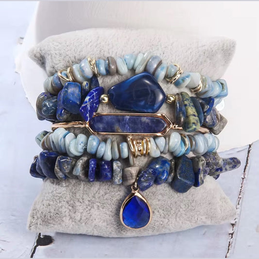 Stack of blue and gold beaded bracelets on a textured surface