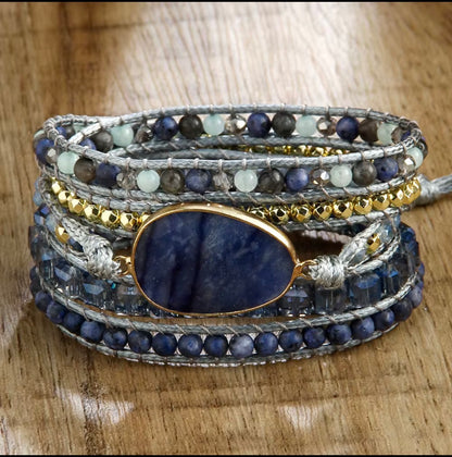 Multi-layered bracelet with blue stone and beads on a wooden surface