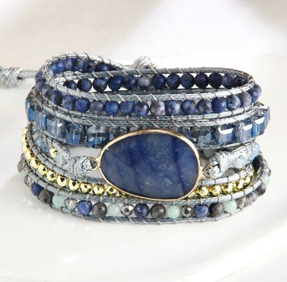 Multistrand bracelet with blue stones and gold accents on a white background