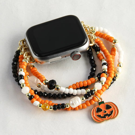 Smartwatch with a beaded Halloween-themed strap featuring a pumpkin charm on a light gray background