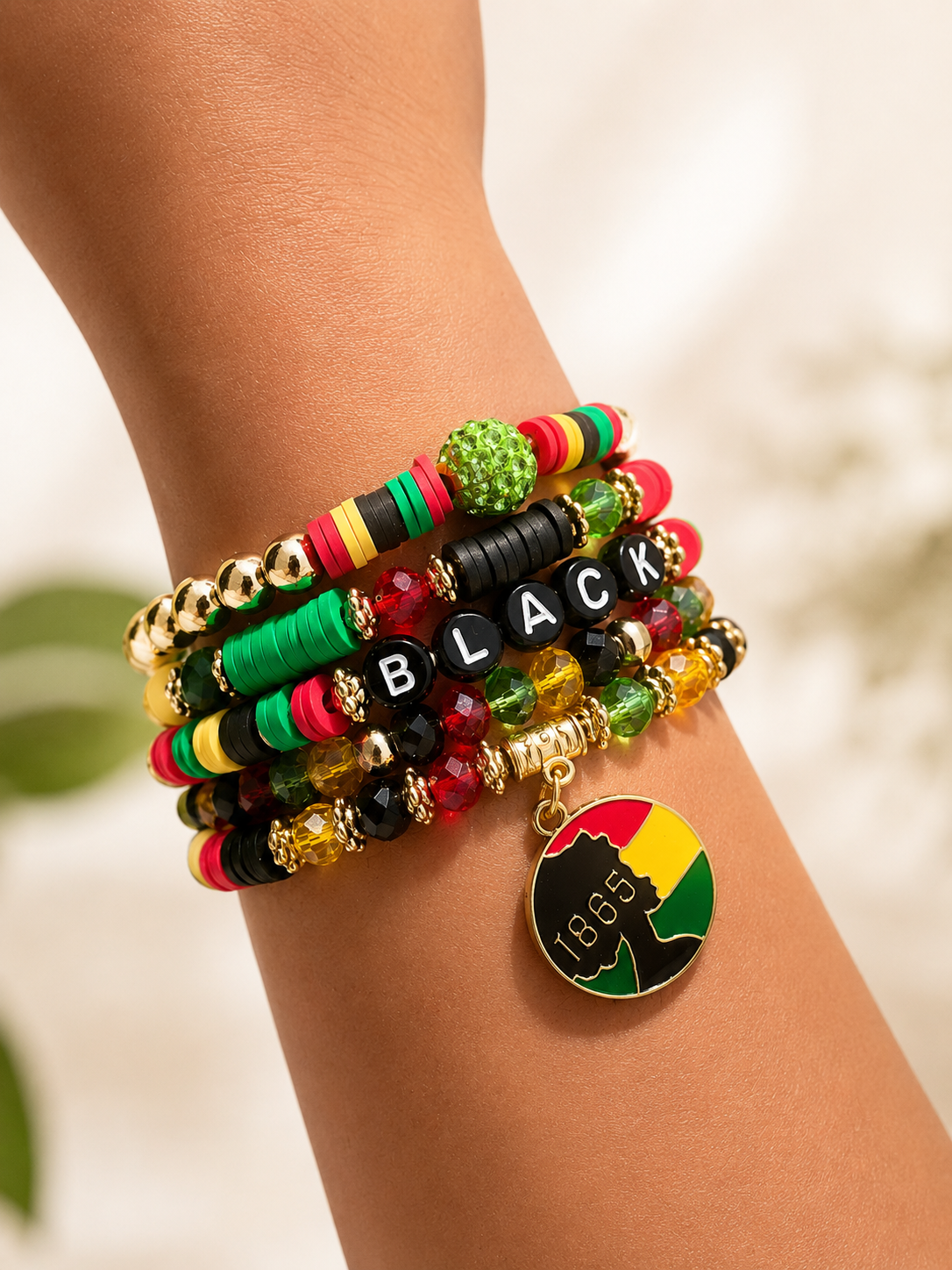 Colorful beaded bracelet with 'BLACK' charm on a wrist against a blurred natural background
