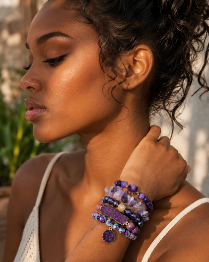 Woman wearing multiple purple beaded bracelets on a blurred natural background