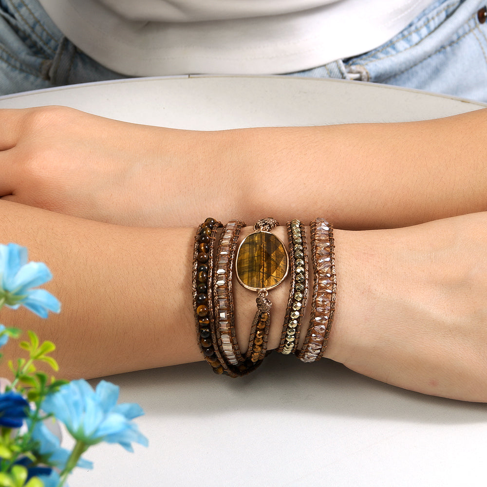 Close-up of a wrist wearing multiple bracelets with a floral background