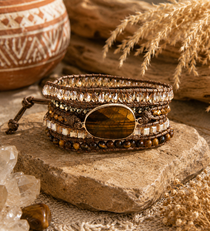 Stacked bracelets with gemstones on a wooden surface with natural elements