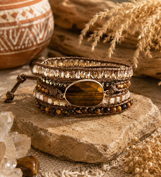 Stacked bracelets with gemstones on a wooden surface with natural elements