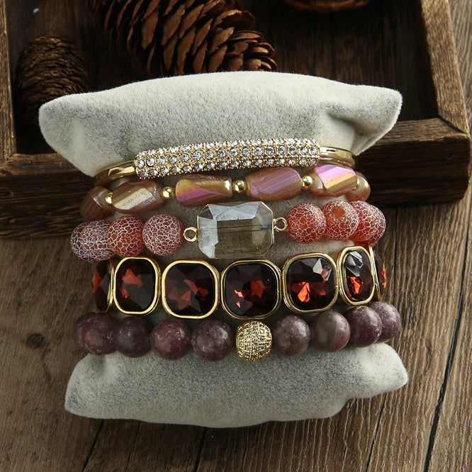 Stack of colorful beaded bracelets on a textured surface with a wooden background