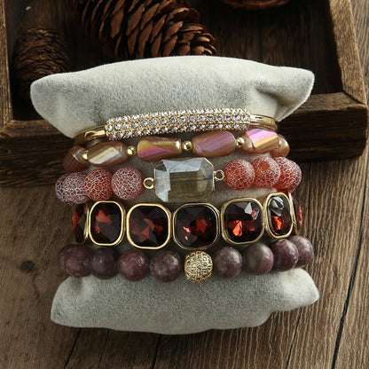 Stack of colorful beaded bracelets on a textured surface with a wooden background