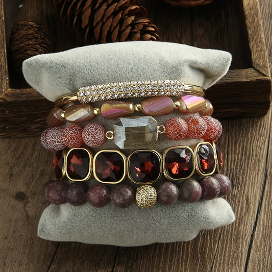 Stack of colorful beaded bracelets on a textured surface with a wooden background