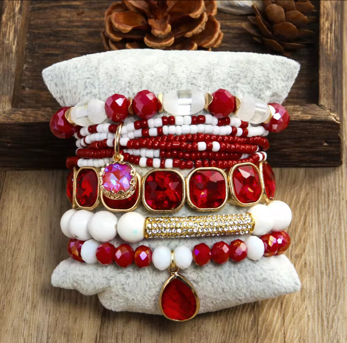 Stack of red and white beaded bracelets on a textured surface with a wooden background