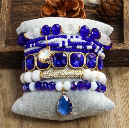 Set of blue and white beaded bracelets on a textured surface with wooden background
